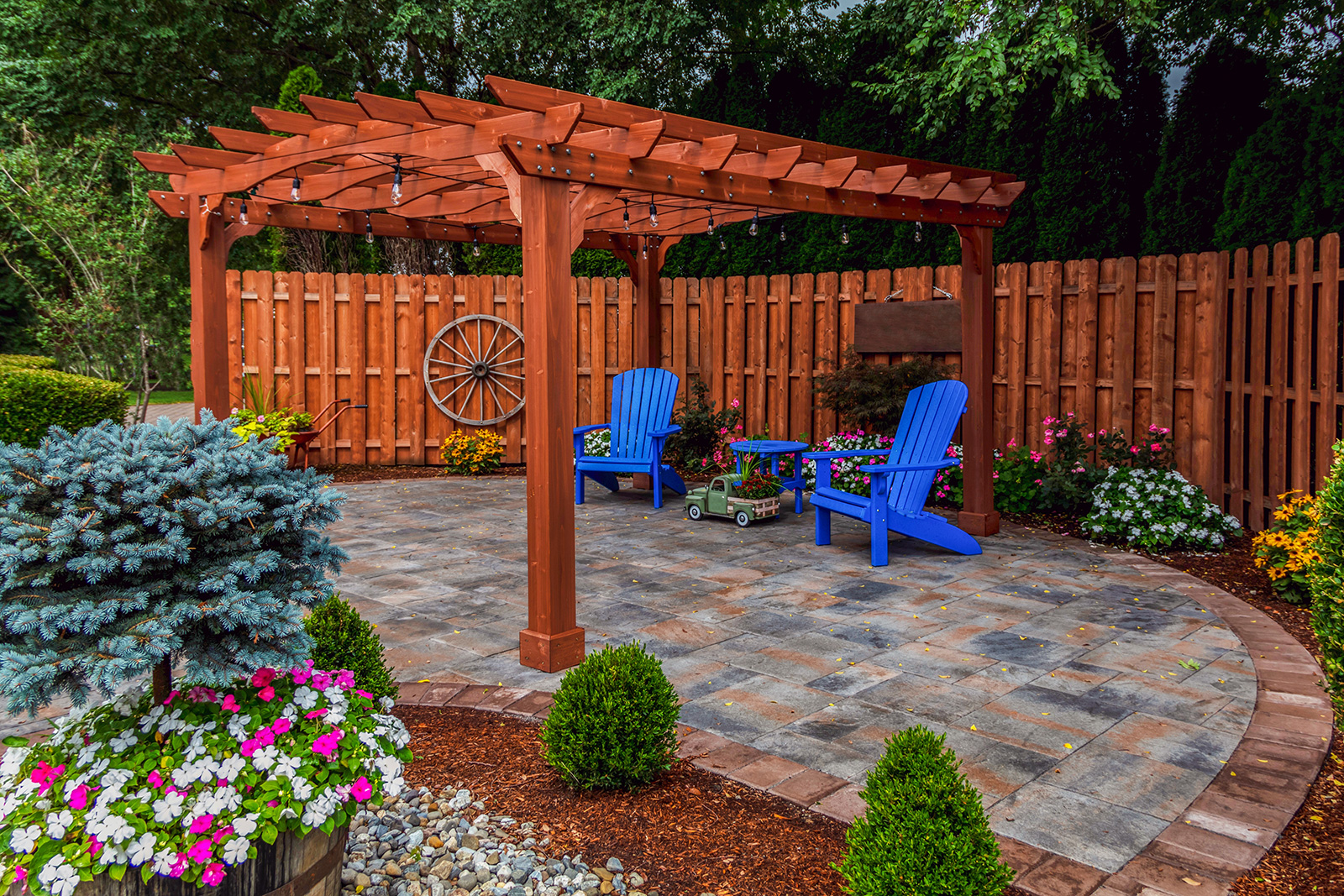 Custom cedar pergola over a paver patio with Adirondack chairs in a North Texas backyard